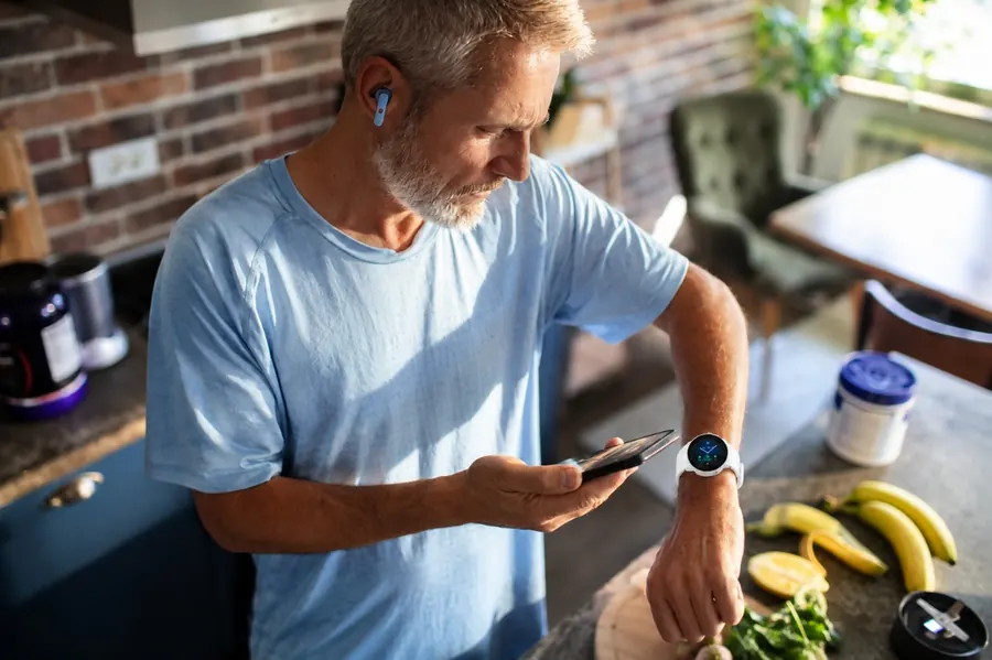 A man checking his LifeLeaf app and watch during his morning routine.